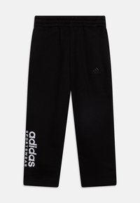 Černé sportovní kalhoty s elastickým pasem, na levé noze s bílým nápisem "adidas" a "SPORTSWEAR" a na pravé straně s raženým logem.