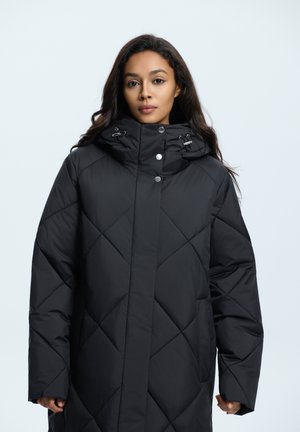 Schwarze Pufferjacke mit hohem Kragen, Rautenmuster und Druckknöpfen. Verfügt über eine lockere Passform und große, gepolsterte Ärmel.