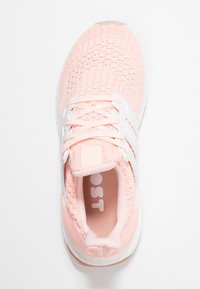 Różowy dzianinowy but sportowy z białymi akcentami i sznurowadłami. Posiada teksturowaną cholewkę, zaokrąglony czubek i wyściełany kołnierz. Lekka gumowa podeszwa.