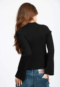 Maglione nero a coste con maniche lunghe, caratterizzato da polsini svasati e una vestibilità aderente. Il materiale sembra lavorato a maglia con una finitura testurizzata.