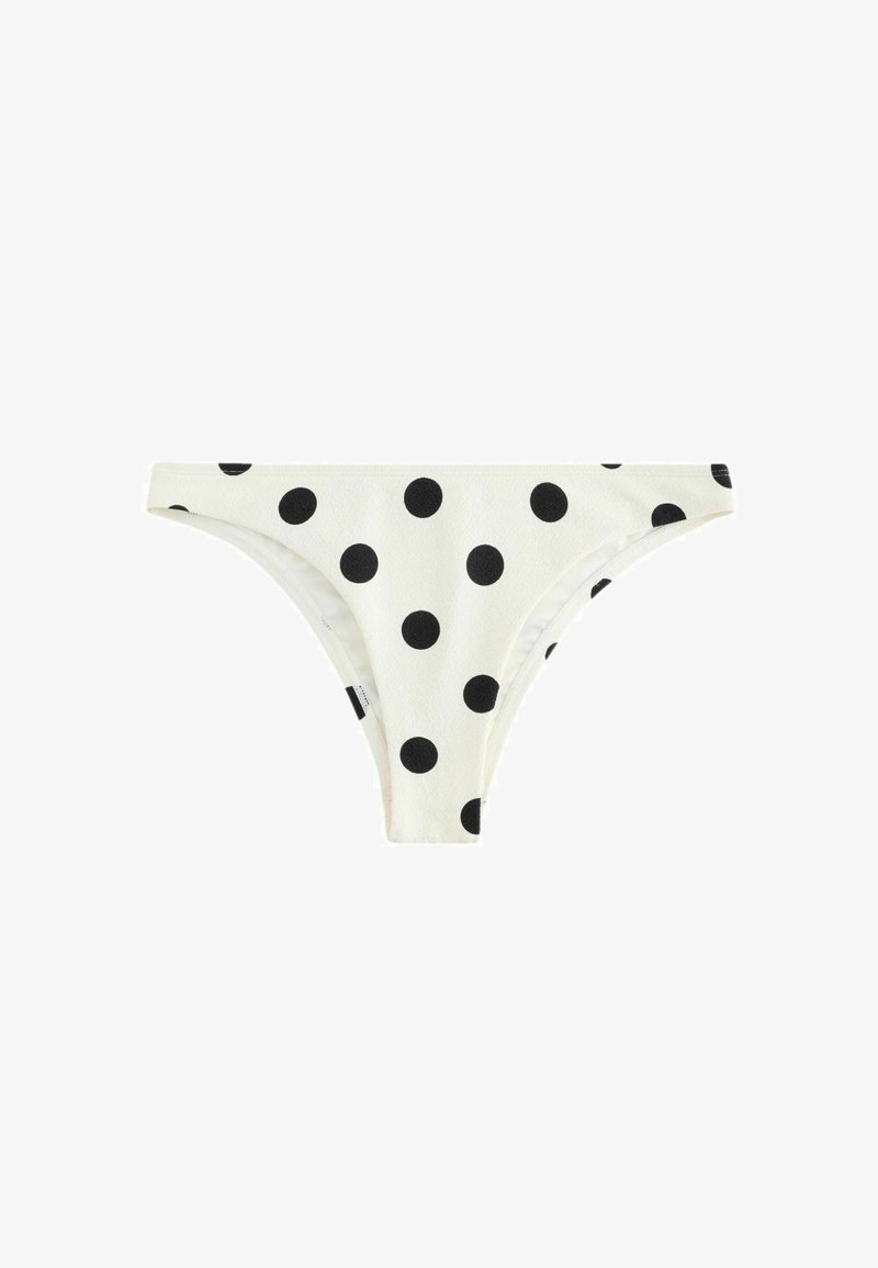 Bas de bikini blanc à pois noirs, taille basse avec taille simple sur fond blanc.
