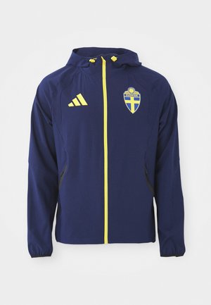 Marineblaue wasserdichte Jacke mit einem gelben Reißverschluss, schwedischem Flaggenemblem und schwarzen Akzenten. Hergestellt aus leichtem, atmungsaktivem Material.