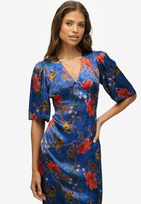 Blauwe bloemenjurk met korte, pofmouwen. Heeft een wikkeldesign versierd met rode, oranje en groene bloemen op een satijnen stof.