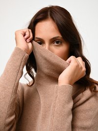Lichtbruine geribde coltrui met lange mouwen, voorzien van een hoge kraag, zachte textuur en een nauwsluitend ontwerp.