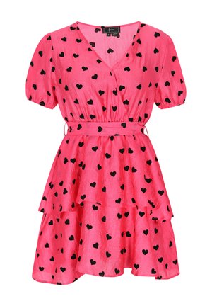 Rozā kleita ar V-veida izgriezumu, īsām pūku piedurknēm, apņemšanas dizainu, pakāpeniski viļņotu apakšmalu un izkaisītu melnu sirds rakstu. Ietver atbilstošu jostu.