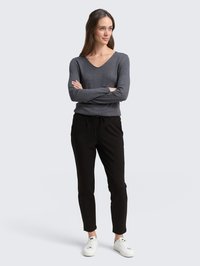 Šedý sveter s výstrihom do V, slim-fit čierne nohavice s nastaviteľným pásom a biele tenisky; mäkká tkanina a čisté línie. Minimalistický dizajn.