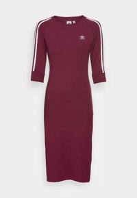 Burgundy klänning i slät tyg, med trekvartsärmar, vita sidostrimmor och en liten logotyp på bröstet.