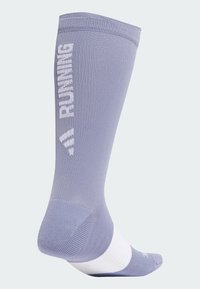 Lichtpaarse hardloopsok met witte tekst "RUNNING", compressieve pasvorm, ribbelachtige bovenkant en witte streep op de kuit. Zachte textuur overal.