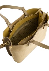 Beżowa torba tote o zamszowej i skórzanej teksturze. Zawiera złote akcesoria, wewnętrzną kieszeń na zamek oraz wyłożoną przegrodę z wzorem logo.