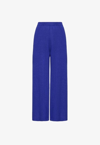 Široke hlače v svetlo modrem materialu z elastičnim pasom, ki imajo gladko teksturo in brez vidnih vzorcev ali kovinskih delov.