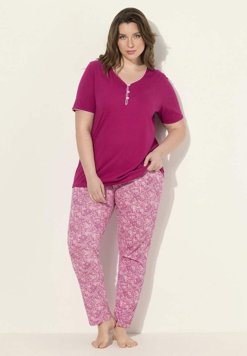 Magenta t-shirt met knoopdetails, gecombineerd met roze paisley-gepatteerde broek. Zachte stof, relaxte pasvorm en lichtgewicht ontwerp.