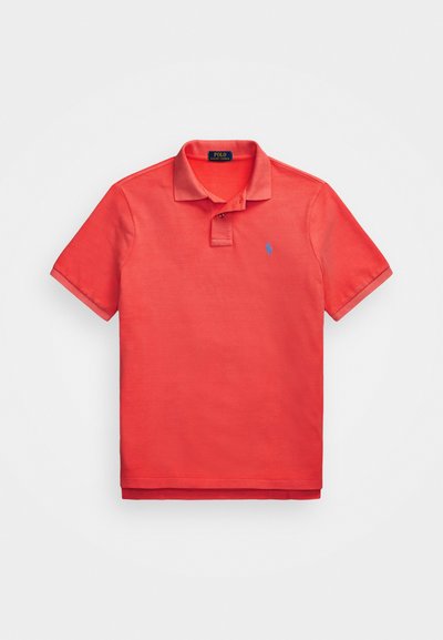 Röd polo skjorta i bomull, med klassisk krage, korta ärmar och en liten blå logotyp på bröstet. Slät textur, inga mönster.