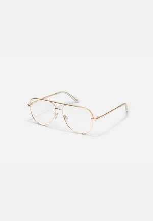 Occhiali stile aviatore con sottile montatura in metallo dorato, lenti trasparenti e aste con punte in plastica trasparente su sfondo bianco.
