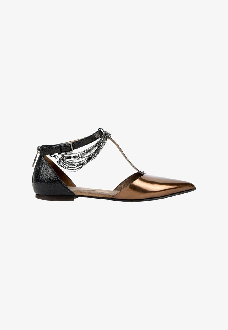 Chaussure plate pointue avec bout en bronze métallique, talon noir texturé, bride à la cheville et chaînes décoratives argentées sur fond blanc.