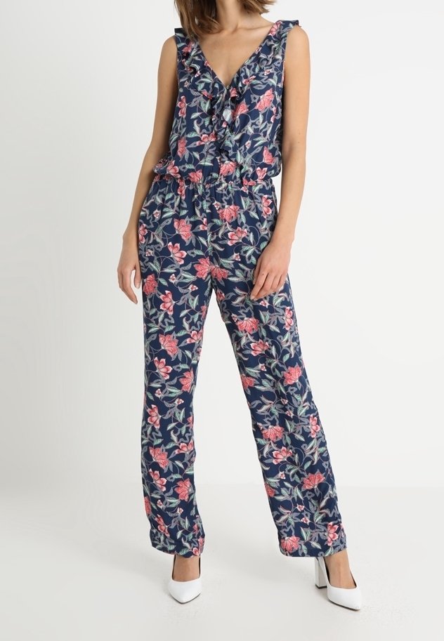 Blommig byxdress i marinblått med rosa och gröna mönster. Har en djup V-ringning, volangaxlar, elastisk midja och vid ben-design.