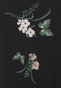 Mustaa kangasta, jossa on kukkakuvio valkoisilla ja vaaleanpunaisilla kukilla, vihreillä lehdillä ja perhosilla vihreän eri sävyissä, yksityiskohtainen ja teksturoitu.