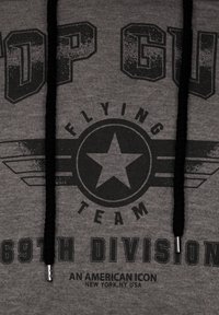 Grå sweatshirt med ett grafiskt tryck med "TOP GUN", en stjärna, vingar och "FLYING TEAM 69TH DIVISION", accentuerad med svarta dragsnören.