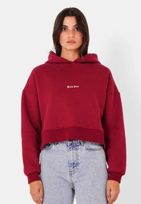 Felpa corta color marsala con cappuccio regolabile, maniche lunghe e polsini a costine. Presenta la scritta bianca "Sixth June" sul davanti.