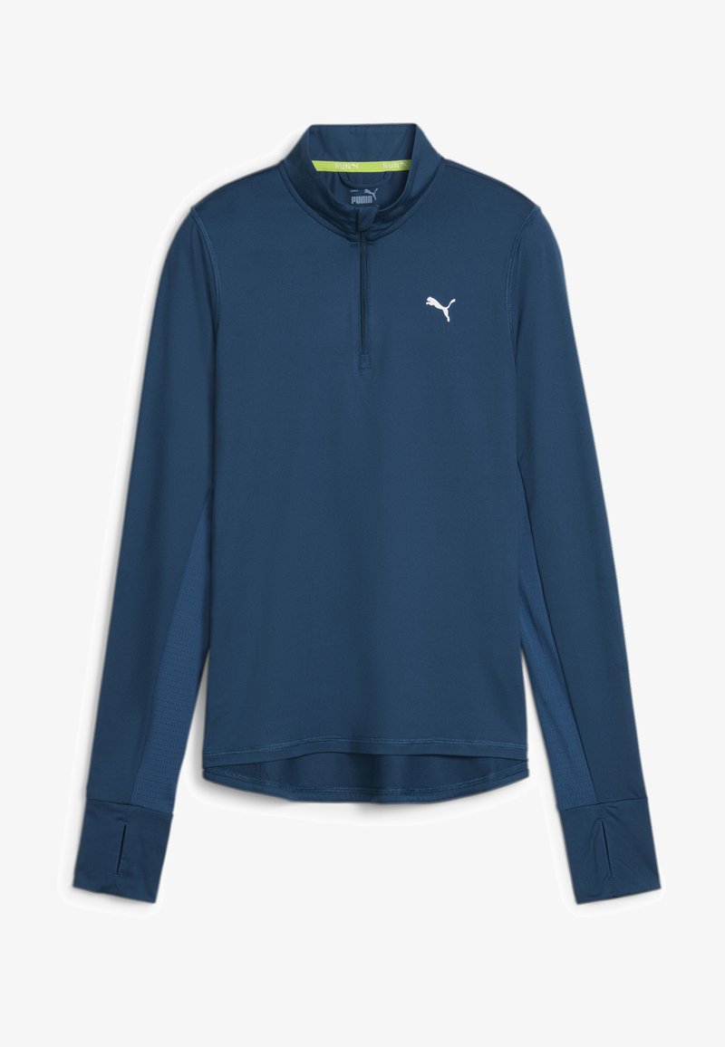 Tengerészkék, hosszú ujjú sport póló félig cipzárral, textúrált oldalsó panelek, hüvelykujjnak való nyílások a mandzsettákban, és fehér logós részlet.