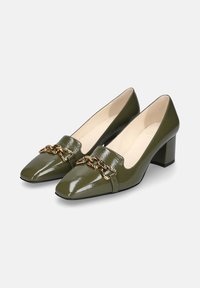 Scarpe verdi in pelle verniciata con tacco a blocco e punta affusolata, adornate da una catena d'oro sul vamp. Texture liscia con un design elegante.