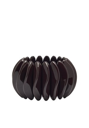 Elastyczna, ciemnobrązowa, błyszcząca bransoletka wykonana z połączonych, zakrzywionych owalnych elementów ułożonych w okrągły wzór.