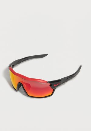 Αθλητικά μαύρα και κόκκινα γυαλιά ηλίου με πορτοκαλί αντανακλαστικούς φακούς και κόκκινο λογότυπο Nike swoosh στο πλευρικό μπράτσο.