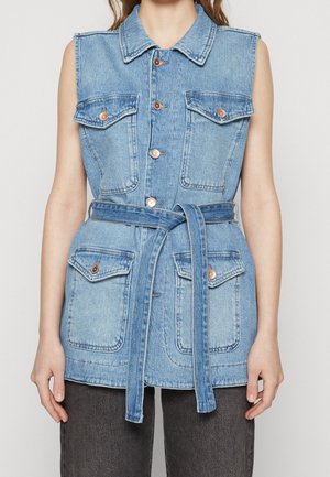Ærmeløs lyseblå denimvest med fire forlommer med klap, knaplukning, spids krave og matchende denimbælte bundet om taljen.