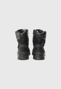Cizme negre până la gleznă, cu un design robust și fermoare la spate, prezentate pe un fundal alb simplu.