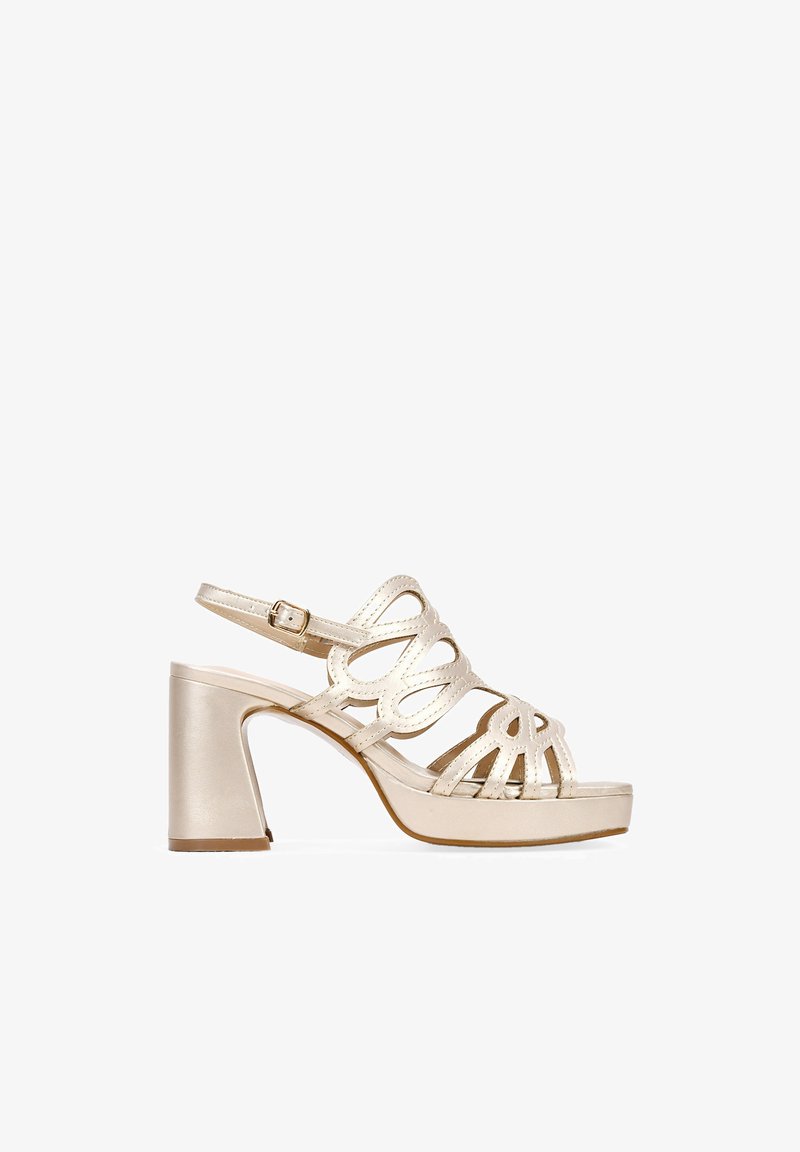 Sandale à talons hauts en or métallisé avec bout ouvert, design de brides entrecroisées, boucle à la cheville et talon bloc empilé. Texture lisse et brillante.