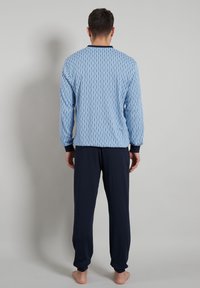 Blue patterned long-sleeve top with navy cuffs, paired with solid navy pants. Cotton fabric with a relaxed fit, plain back view.