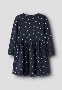 Sukienka z długim rękawem w kolorze granatowym w groszki. Wykonana z miękkiego materiału, ma marszczoną talię i rozszerzany dół.