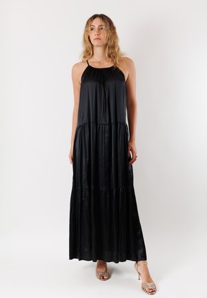Abito maxi nero realizzato in tessuto morbido con un design a strati e livelli. Presenta spalline sottili e una vestibilità comoda. Messo in risalto da una silhouette fluida.