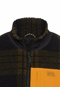Fleece-Jacke mit hohem Kragen, dunkelblau und braun kariert, mit einer gelben Tasche und kontrastierenden Reißverschlüssen. Weicher Stoff.
