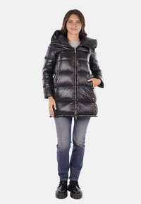 Giubbotto a vento nero con finitura lucida, cappuccio, zip frontale e due tasche laterali. Il giubbotto presenta un design trapuntato e una lunghezza media.