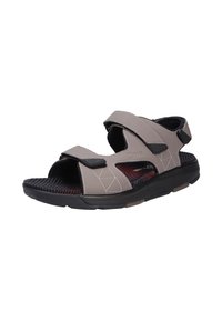 Sandalias grises con dos correas ajustables, suela negra, plantilla texturizada con un patrón en cuadrícula y un acento rojo debajo de la plantilla.