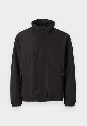 Veste légère noire avec un col montant, des poches latérales zippées, des poignets élastiques et une coupe décontractée. Matière lisse et résistante à l'eau.