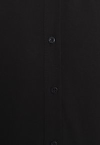 Camicia nera con bottoni, caratterizzata da una superficie liscia e opaca, con sei bottoni sul davanti e un colletto classico.