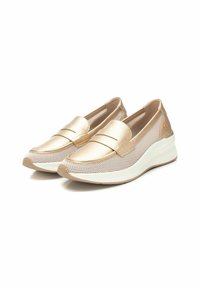 Zapatillas slip-on doradas con upper de malla, suela blanca acolchada y dos acentos horizontales en el empeine. Acabado texturizado para mayor transpirabilidad.