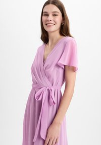 Lavendelfarbenes Wickelkleid mit kurzen Volantärmeln, tailliert. Glatter, leichter Stoff mit einem subtilen Glanz. V-Ausschnitt-Design.