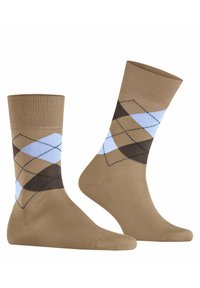 Brązowe skarpetki w romby w jasnoniebieskim i brązowym kolorze. Posiadają ściągacz i gładką teksturę.