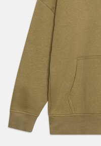 Hoodie vert olive avec une poche frontale, des poignets côtelés et un tissu texturé. Le design comprend une coupe décontractée et des coutures d'épaule sans couture.