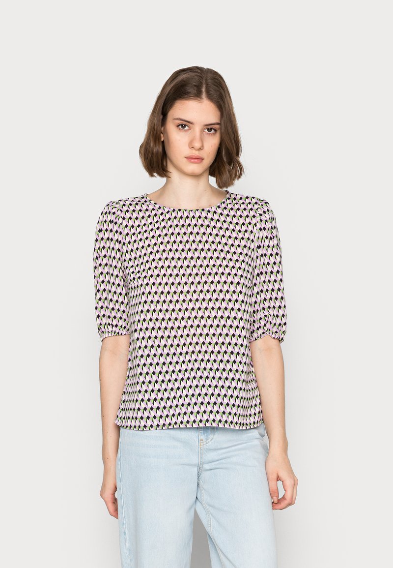 Blusa de manga curta com um padrão geométrico em rosa, roxo e preto, com um corte descontraído e gola redonda. Textura do tecido suave.