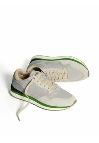 Sneakers in suede grigio e tessuto con suola color crema e dettagli verdi. Presentano una punta tonda e lacci piatti. Design elegante, adatto per un look casual.