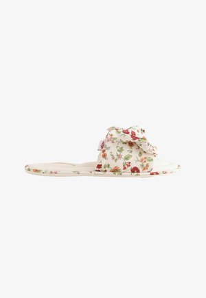 Soft slipper with a floral pattern, open back, and a fabric bow on the top band, shown from the side on a white background.