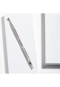 Metal neglebåndskubber med tekstureret greb, aflang form og buet spids. Fremstillet i blankt sølv med "Rustfrit" indgraveret på siden.