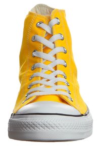 Baskets montantes en toile jaune avec des lacets blancs, des œillets en argent et un capuchon en caoutchouc avec une semelle texturée.