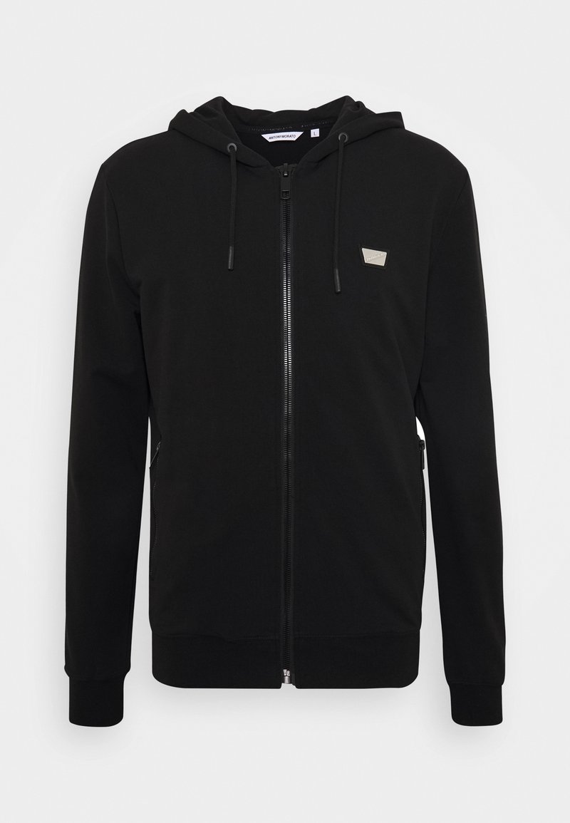Felpa nera con zip realizzata in morbido misto cotone, con cappuccio piatto, cordino, tasche laterali e un piccolo logo sul petto.