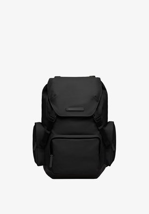 Sac à dos noir en tissu durable, avec un rabat supérieur, des bretelles réglables, une poche avant et des poches en filet sur les côtés pour le stockage.