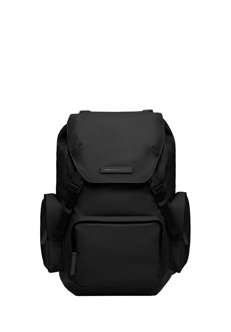 Sac à dos noir en tissu durable, avec un rabat supérieur, des bretelles réglables, une poche avant et des poches en filet sur les côtés pour le stockage.