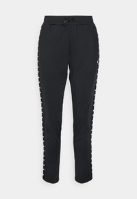 Pantalon décontracté noir avec taille élastique et cordon de serrage, présentant un motif en forme de losange blanc courant le long des coutures latérales.